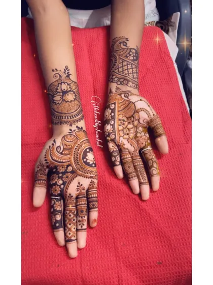A full view of a designer mehendi, with one hand featuring a modern peacock cuff and the other a more traditional design.