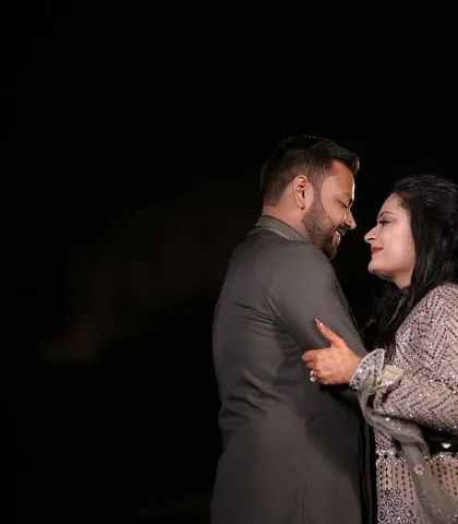 A simple yet powerful portrait against a dark background. The focus is entirely on the couple's connection and the way they look at each other, creating a timeless and romantic image.