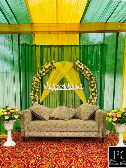 The clean and elegant Mehndi stage, ready for the couple. The combination of green, yellow, and a traditional carpet creates a classic and festive feel.