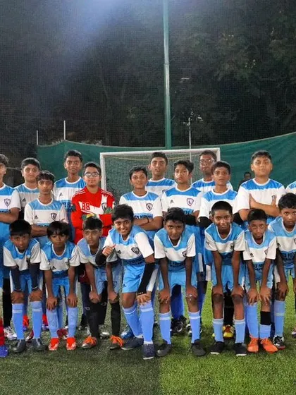The full squad of our youth team posing for a photo under the lights at Sadashivanagar.