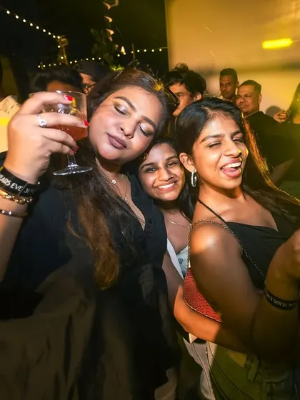 Friends enjoying drinks and music. It's a social gathering, not just a concert.