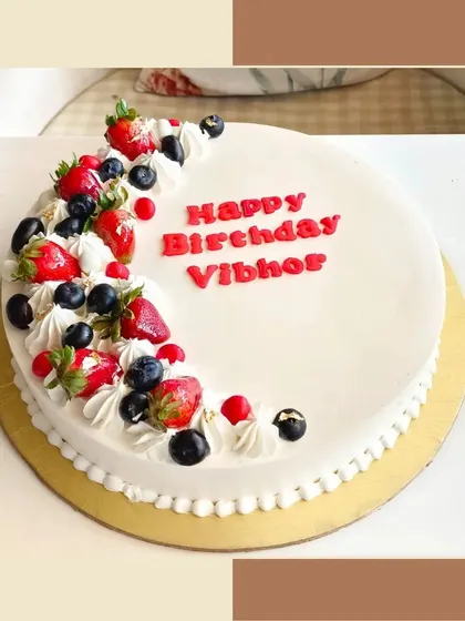 A simple and elegant fresh fruit cake, topped with fresh strawberries and blueberries.