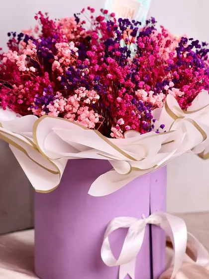 A still shot of our stunning Mother's Day flower box, featuring a vibrant bouquet of pink and purple preserved baby's breath.