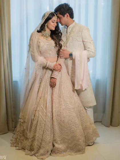 A regal and elegant portrait of the couple in their coordinated white and silver wedding attire, exuding timeless grace.