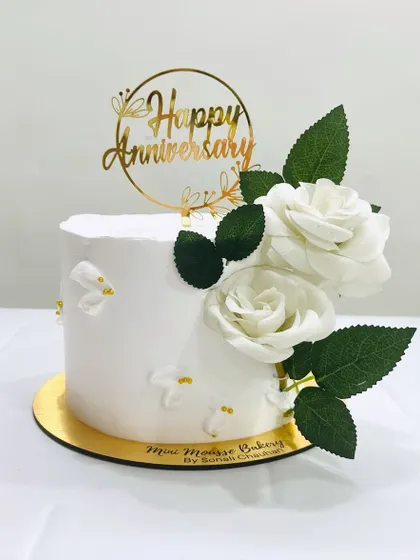 Simplicity at its best. This anniversary cake is decorated with just a few elegant white roses and leaves, proving that less is often more.