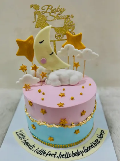 Another beautiful "Twinkle Twinkle" baby shower cake, with a sleeping moon nestled in fondant clouds and surrounded by golden stars.