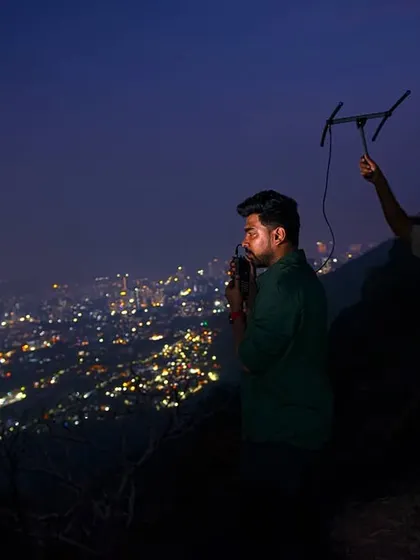 A wildlife researcher and a forest department official track a radio-collared leopard at night. This collaborative project is essential for understanding how leopards use the urban landscape, providing data for better management and conflict mitigation.