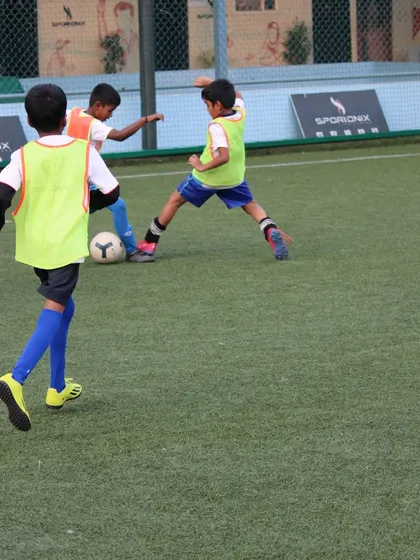An action shot from our tournament, with players in bibs competing for the ball in a fast-paced game.