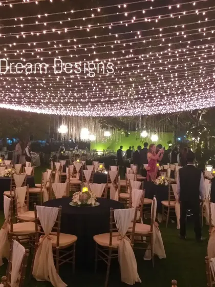 A canopy of fairy lights creates a ceiling of stars for this outdoor reception. The simple yet effective lighting design transforms the entire space into a magical and inviting environment.
