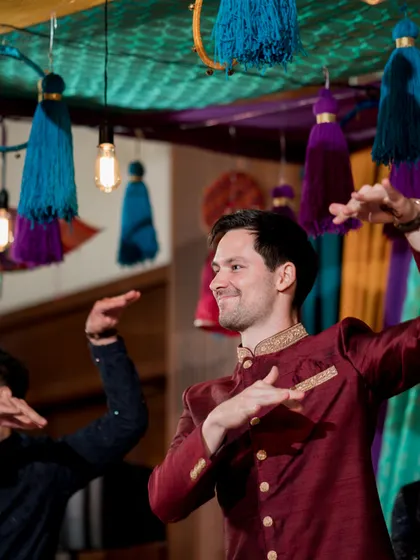 The groom's friends put on a fantastic performance at the Sangeet. The colorful decor with large tassels and warm lighting added to the festive energy.