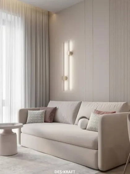 Soft and inviting, this living room uses a neutral color palette and textured wall panels to create a sense of calm. The vertical sconces add a touch of modern elegance.