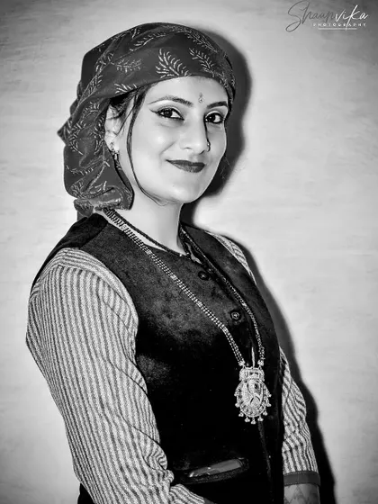 A classic black and white portrait of a bride in traditional Himachali attire. This timeless style emphasizes her expression and the textures of her clothing.