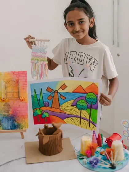 A beautiful collection of art from a single camper, including a landscape drawing and a woven wall hanging. Our camps are designed to let kids explore a wide range of artistic mediums.