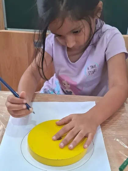 A student uses a circular block to trace the layers of the Earth. This activity combines geometry with science, making learning about our planet interactive.
