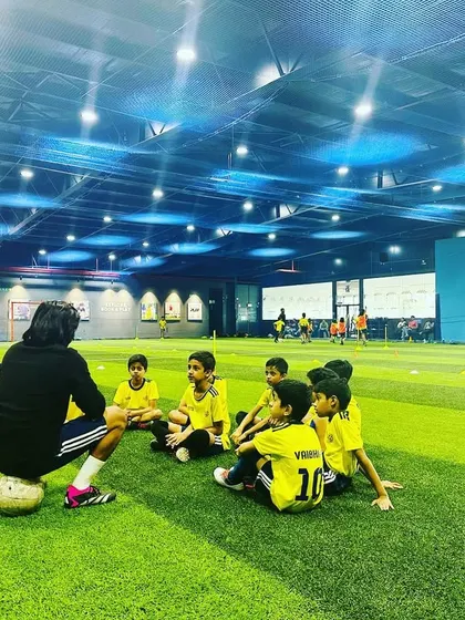 A coach sits on a football while talking to his team. We keep the atmosphere light and friendly.