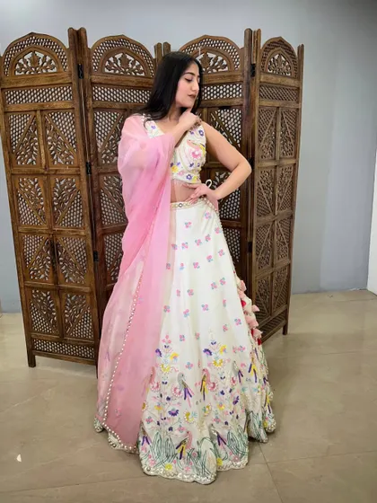 This white lehenga with colorful bird and floral embroidery is a whimsical and unique choice for a day event.