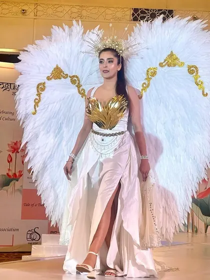 An avant-garde creation with dramatic angel wings, designed by our students for the 'Tale of a Trend' fashion show.