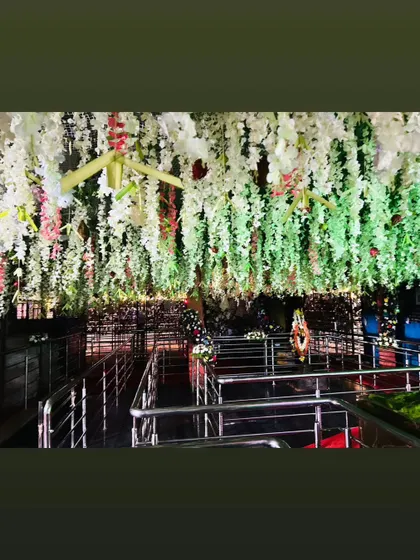 Another view of the temple ceiling, showing long strands of white flowers hanging down, creating a beautiful floral canopy.