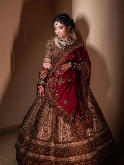 A full-length shot of Lavanya's magnificent reception lehenga. The rich maroon and gold tones are complemented by her elegant makeup and hairstyle, creating a look worthy of a magazine cover.