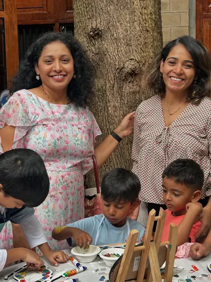 Parents love to watch and sometimes even join in. Here, two mothers are enjoying the creative atmosphere as the kids work on their mosaics.