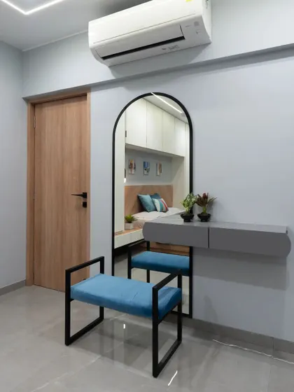 This exquisite dressing table is the epitome of elegance. The arched mirror, floating grey drawer, and stylish blue bench create a minimal yet highly chic makeup corner.