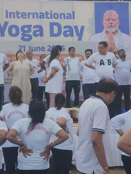 Participants engage in yoga asanas during the International Yoga Day event. The live tabla music in the background is not just accompaniment but an integral part of the experience, designed to enhance focus and flow.