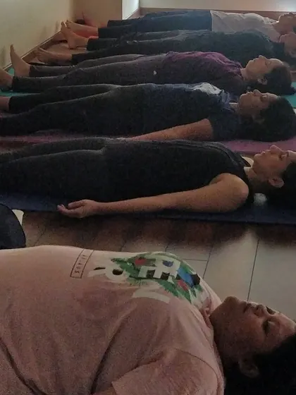 A line of mothers-to-be resting in Savasana, the final and most important pose. This is where the body heals, the mind quiets, and you connect with your baby in perfect stillness.