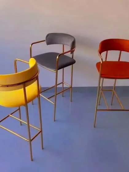 These high counter chairs feature a sleek, gold-plated metal frame and are available in vibrant colors. They add a touch of modern elegance to any bar or high-top seating area in a restaurant or cafe.