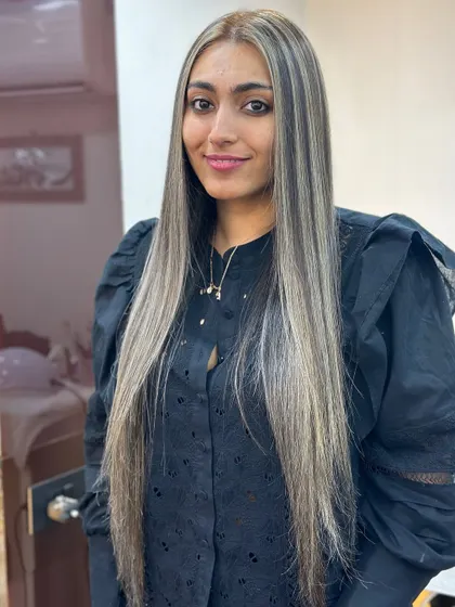A stunning ash highlights transformation on very long, straight hair. The cool tones create a sleek and sophisticated look.