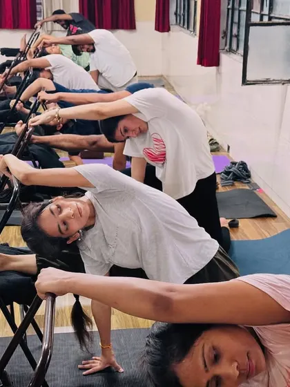 Another view of our chair yoga practice, with students in a side stretch. This shows how we adapt classical poses to make them accessible to all.