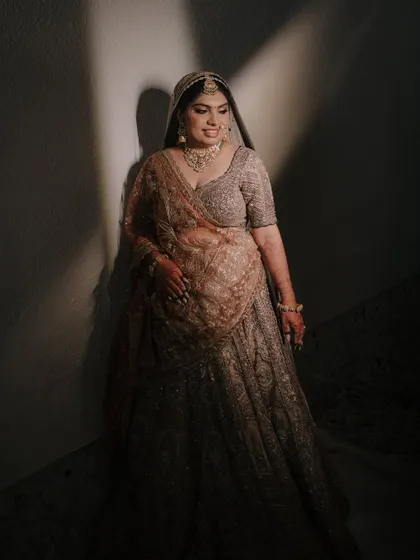 A full-length bridal portrait with artistic use of shadow and light, creating a sense of anticipation and elegance.