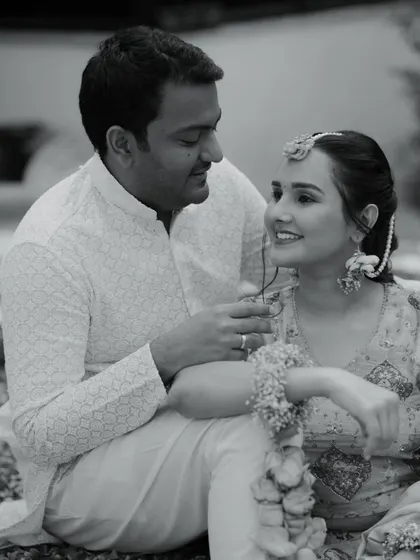 A classic black and white portrait of the couple, capturing a moment of quiet conversation and connection. The timeless quality of the photo emphasizes their bond.