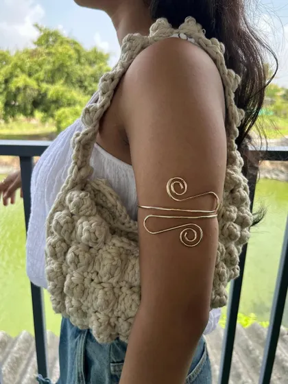 A side view of the puff stitch bag, showing how comfortably it sits on the shoulder. The strap is also crocheted with a sturdy stitch to ensure it's durable.