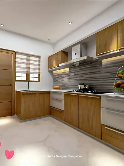 A simple and clean L-shaped kitchen with wood-grain cabinets and a grey textured backsplash. This is a great example of a functional and budget-friendly design.