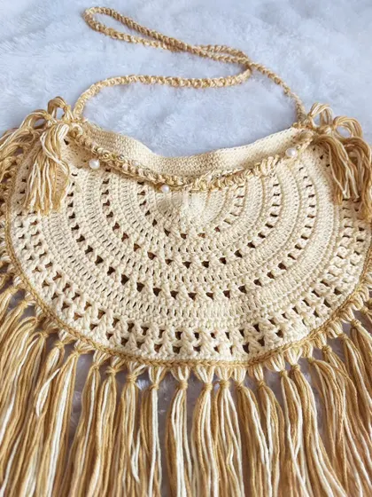 A detailed flat-lay of the Callaia Bag, focusing on the intricate stitchwork and the texture of the fringe.
