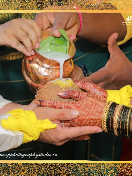 A close-up of a traditional ritual involving pouring milk over a coconut. We document these unique cultural practices that make each wedding special.