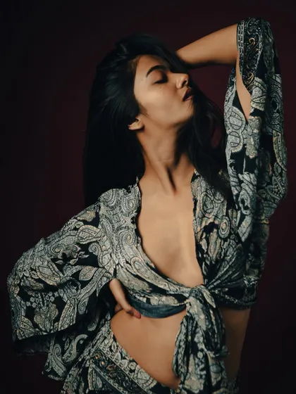 A powerful and sensual pose that highlights the model's form and the flowing fabric of the outfit.