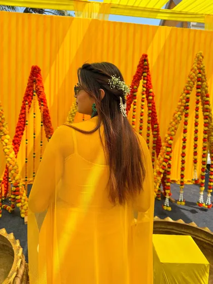 A cool and chic Haldi bride. The simple braided hairstyle looks great with sunglasses and adds a modern twist to the traditional look.