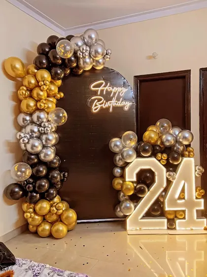 A different view of the 24th birthday setup, highlighting the contrast of the balloons against the black backdrop.