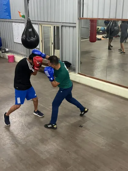 The action continues. Here, one boxer throws a cross while the other maintains a tight guard, demonstrating a fundamental defensive posture.