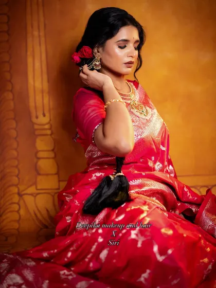 The vibrant red of the saree pops in this artistic photo, complemented by the soft, romantic makeup and hairstyle.