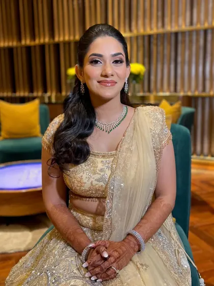 A beautiful Sangeet look in a gold lehenga. The makeup is warm and shimmery, with a focus on bronzed, glowing skin.