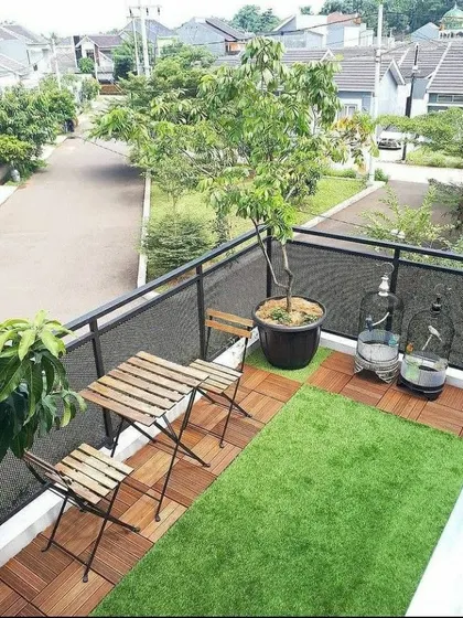 A simple and functional balcony setup. We used artificial grass and wooden tiles to create a clean, green space with a small seating area, perfect for enjoying the neighborhood view.