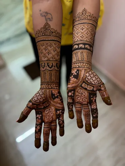 This design combines traditional geometric patterns with a band of elephants, a favorite motif in South Indian weddings. You can even spot a personal tattoo integrated into the design.