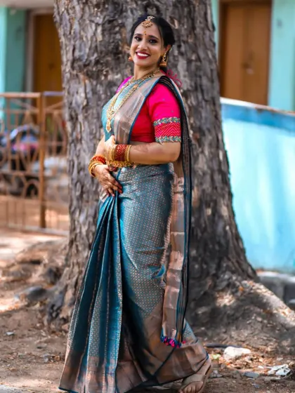 A happy bride is the most beautiful bride. Here she is, glowing in a custom blue silk saree with a contrasting pink embroidered blouse for one of her wedding functions.
