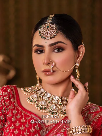 Another close-up, this time highlighting the intricate details of the kundan and pearl jewelry set against the red lehenga.