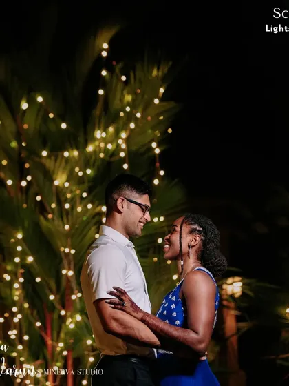 A quiet moment together amidst the celebration. The couple shares a smile against a backdrop of firefly lights, a simple yet magical setting that highlights their love.