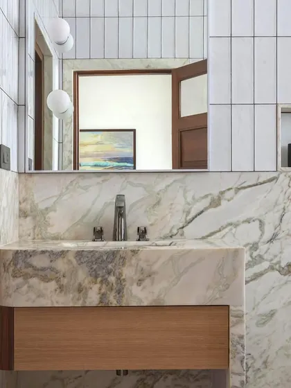 A bathroom in Apartment 5026, where we combined classic marble with simple white tiles and a wooden vanity.