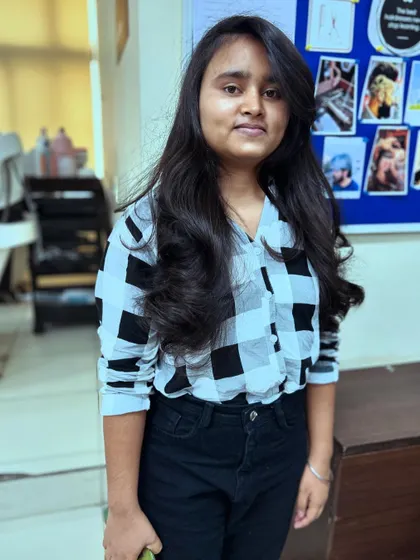 A student proudly displays her new layered haircut. Our courses teach students how to create cuts that are not only stylish but also easy for clients to manage at home.