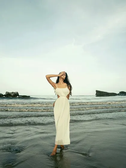 A full-length portrait on the beach, capturing a sense of peace and solitude. The vastness of the sea and sky creates a beautiful, cinematic frame.